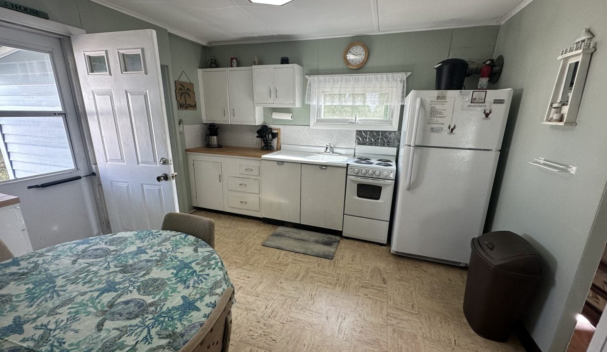 A kitchen with a table and chairs and a refrigerator.