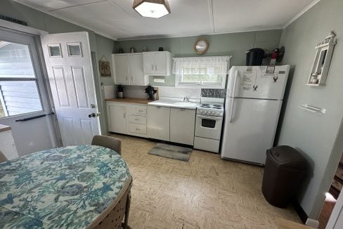 A kitchen with a table and chairs and a refrigerator.