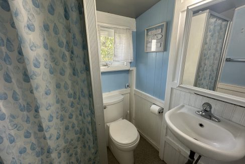 A bathroom with blue curtains and a sink.