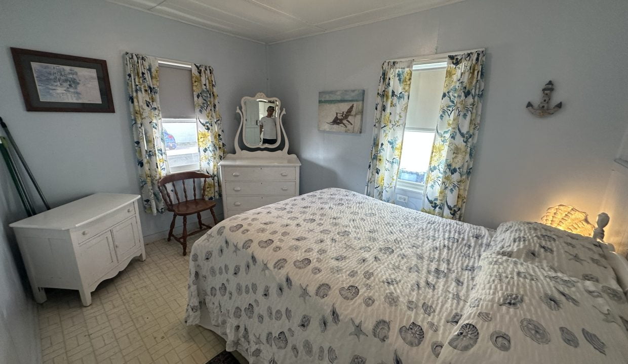 A bedroom with a bed and a dresser.