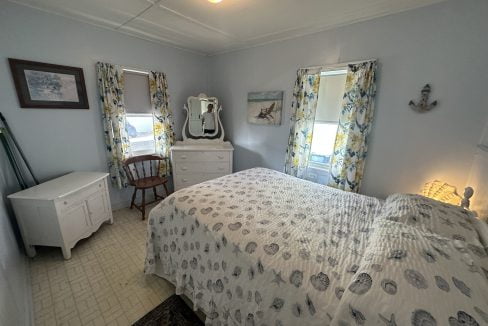 A bedroom with a bed and a dresser.