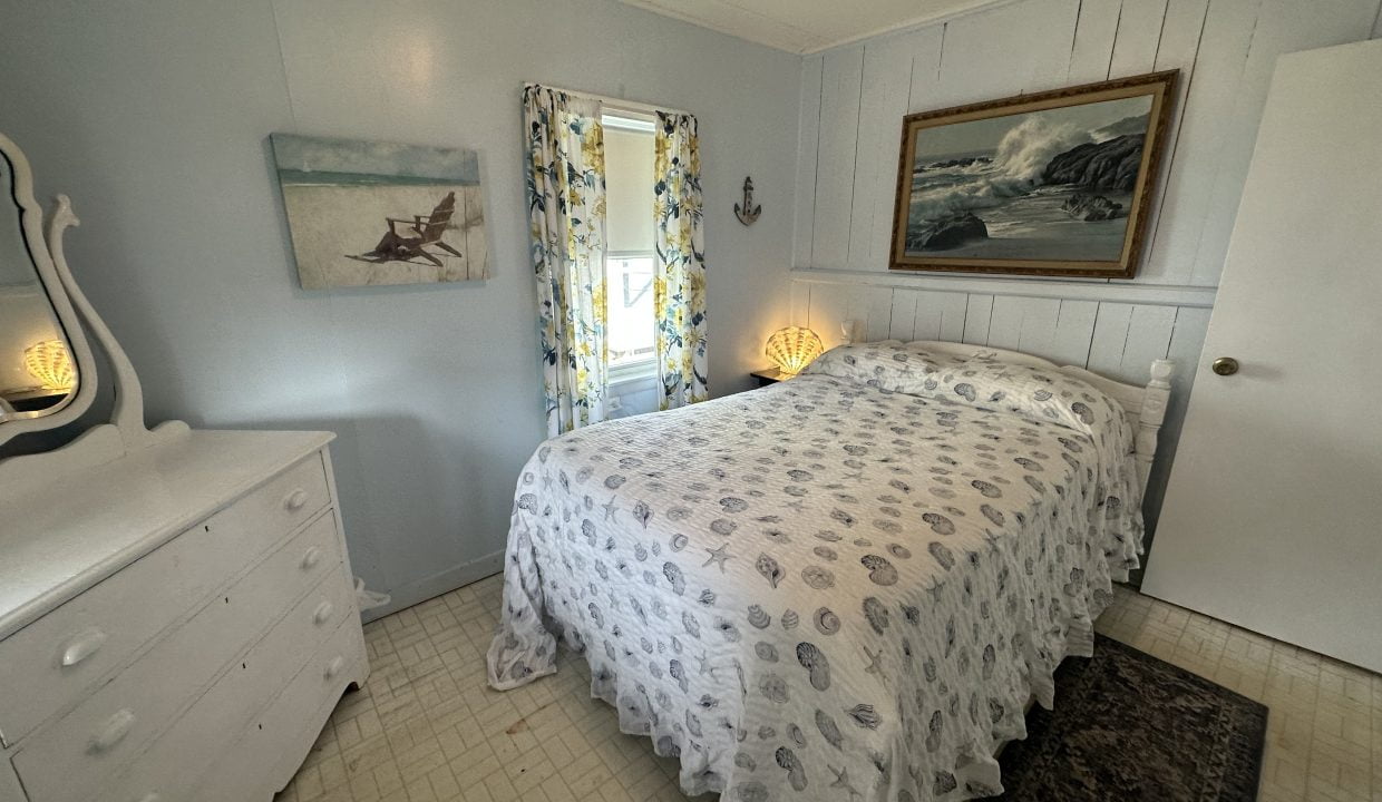 A small bedroom with a bed and dresser.