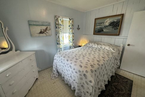 A small bedroom with a bed and dresser.