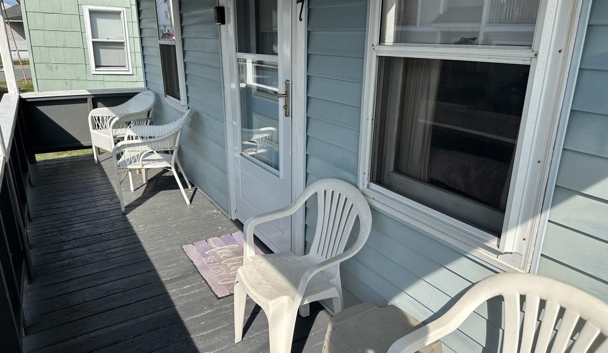 A porch with two chairs and a table.