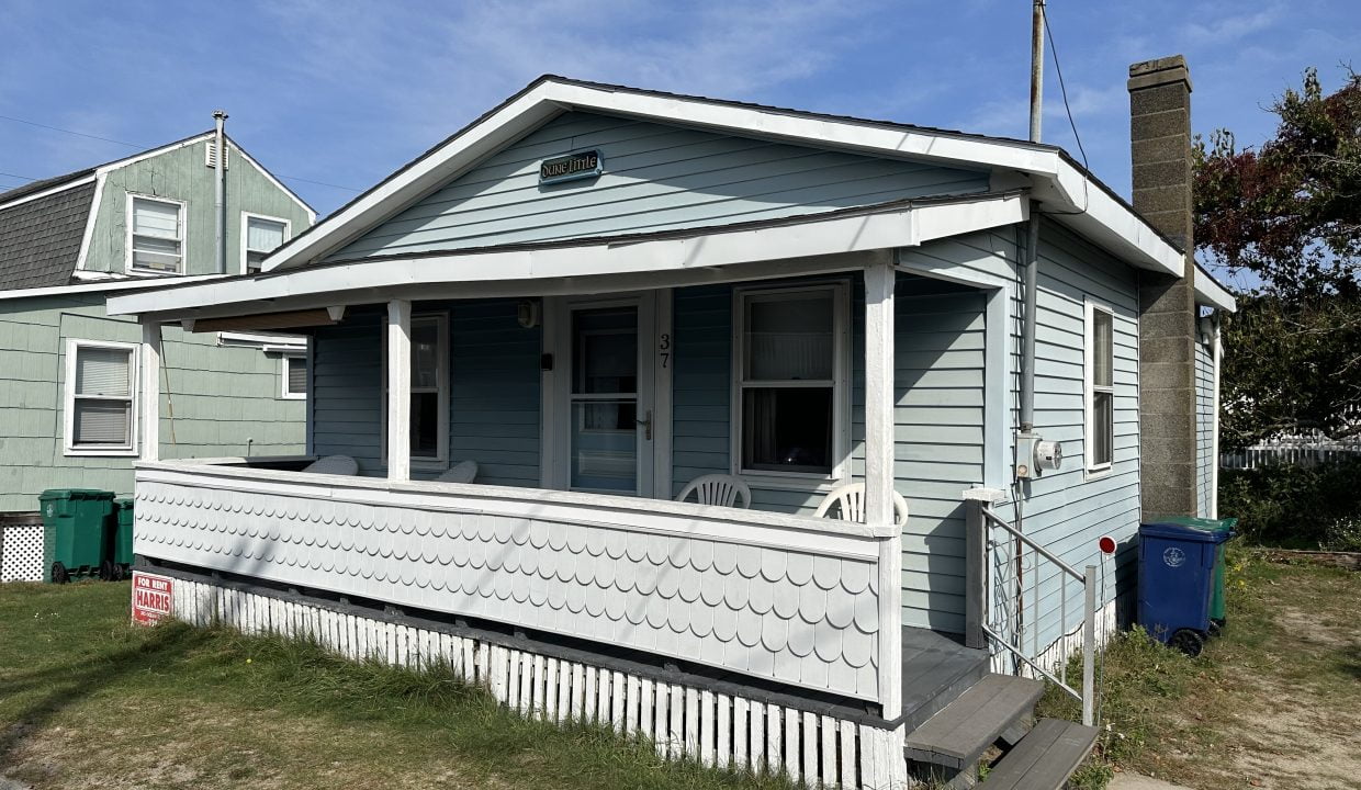 A small house with a porch on the side of it.