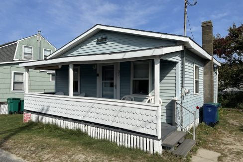 A small house with a porch on the side of it.