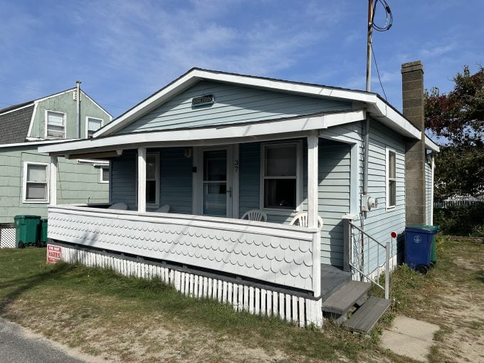 A small house with a porch on the side of it.