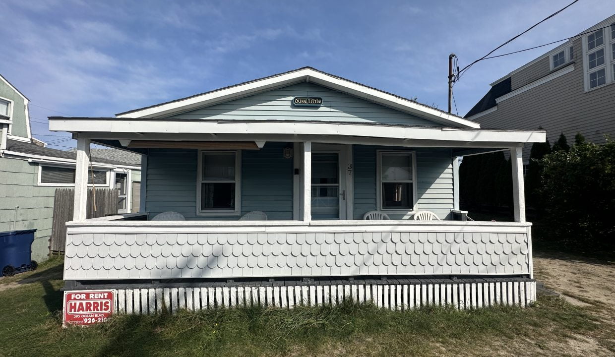 A blue house with a sign on it.