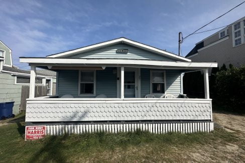 A blue house with a sign on it.