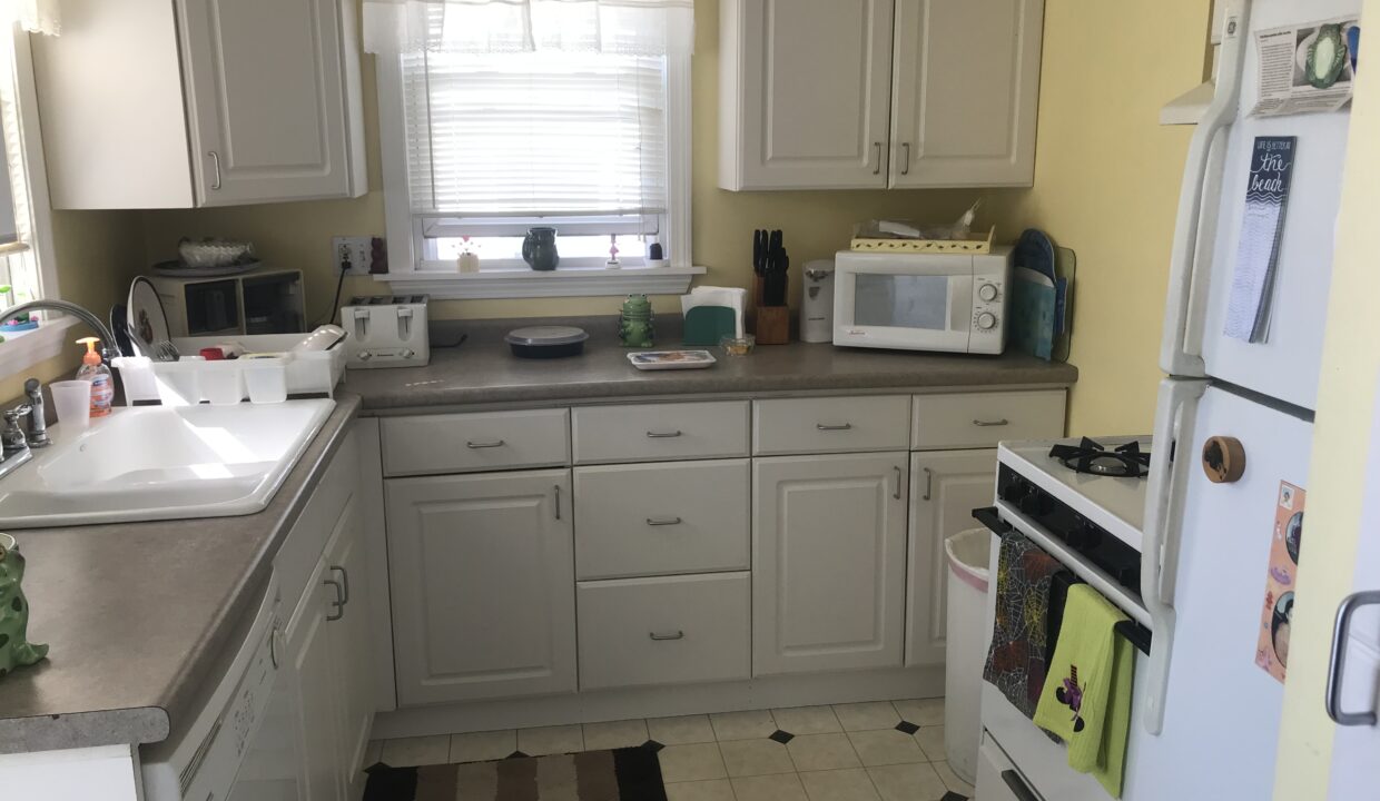 a kitchen with a sink, stove, microwave and refrigerator.