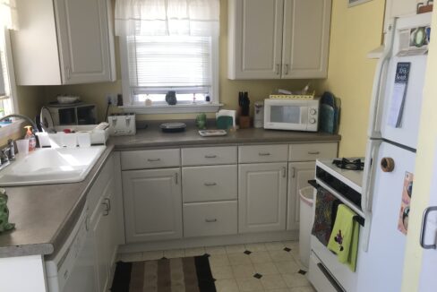 a kitchen with a sink, stove, microwave and refrigerator.