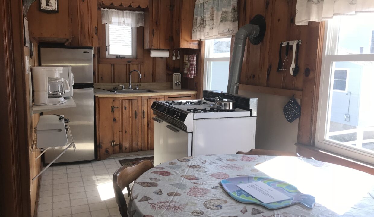 a kitchen with a table a stove and a sink.