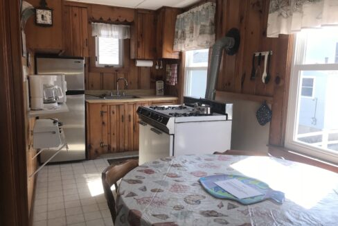 a kitchen with a table a stove and a sink.