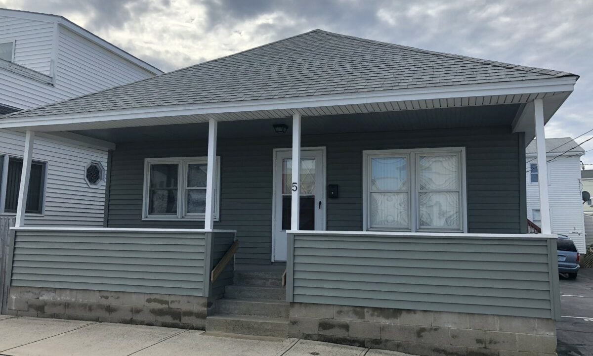 a gray house with white trim and a gray roof.