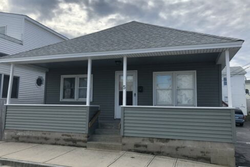 a gray house with white trim and a gray roof.