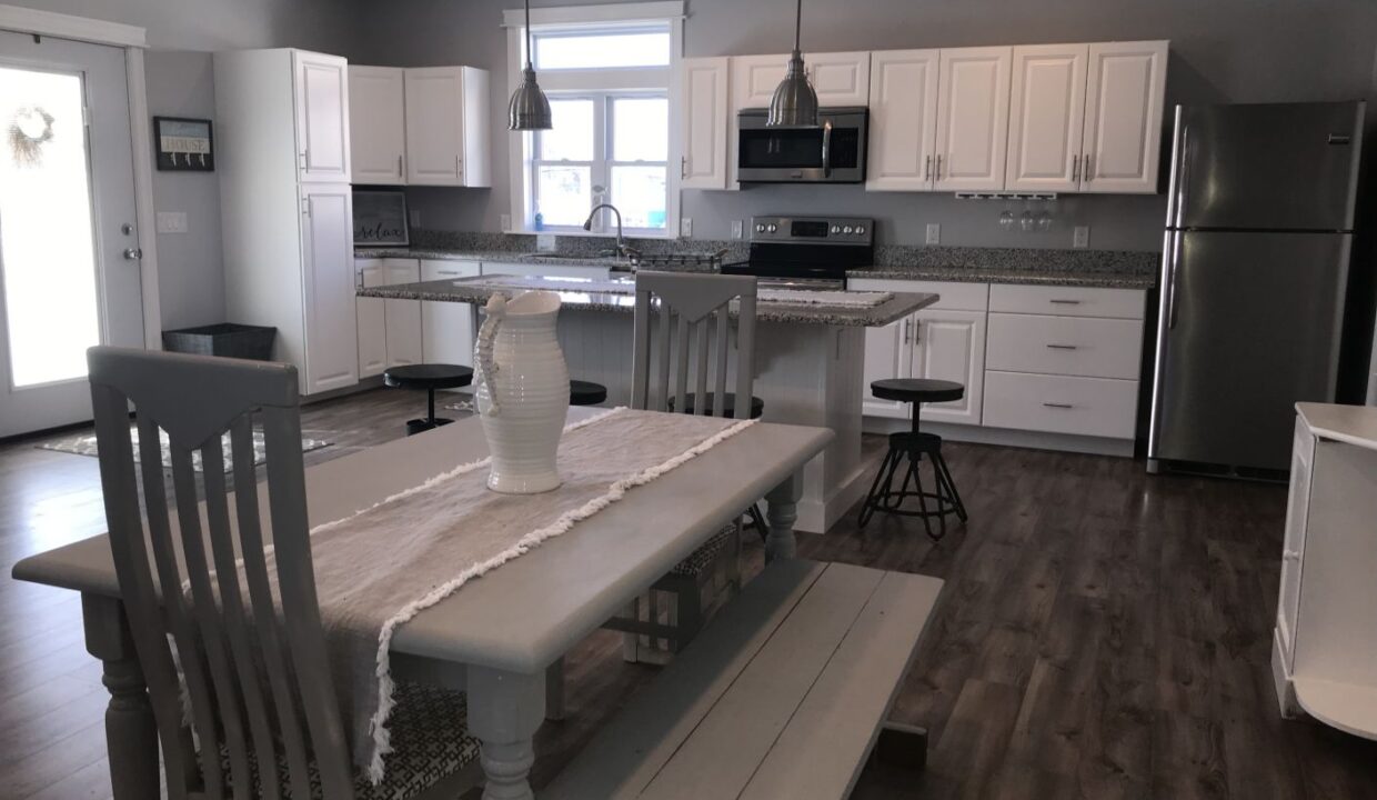 a kitchen with a table and chairs and a refrigerator.