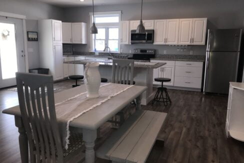 a kitchen with a table and chairs and a refrigerator.