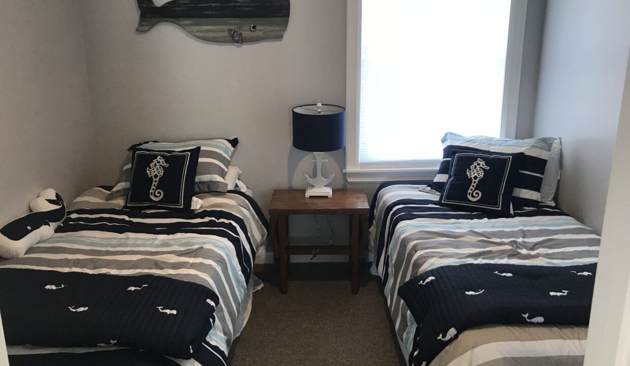 a couple of beds sitting in a bedroom next to a window.