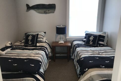 a couple of beds sitting in a bedroom next to a window.
