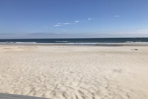 a bench sitting on top of a sandy beach.