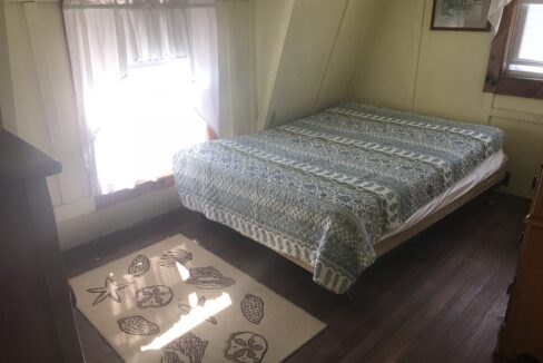 a bed sitting in a bedroom next to a window.