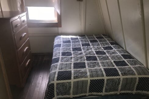 a bedroom with a bed, dresser and window.