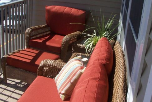 a red couch sitting on top of a wooden deck.