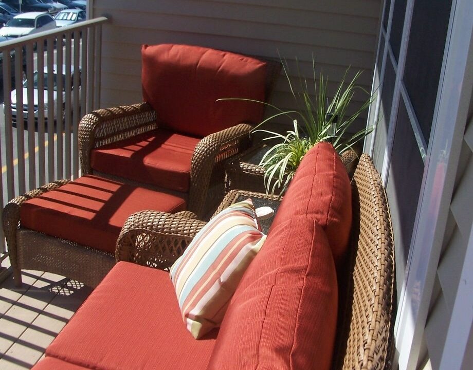 a red couch sitting on top of a wooden deck.