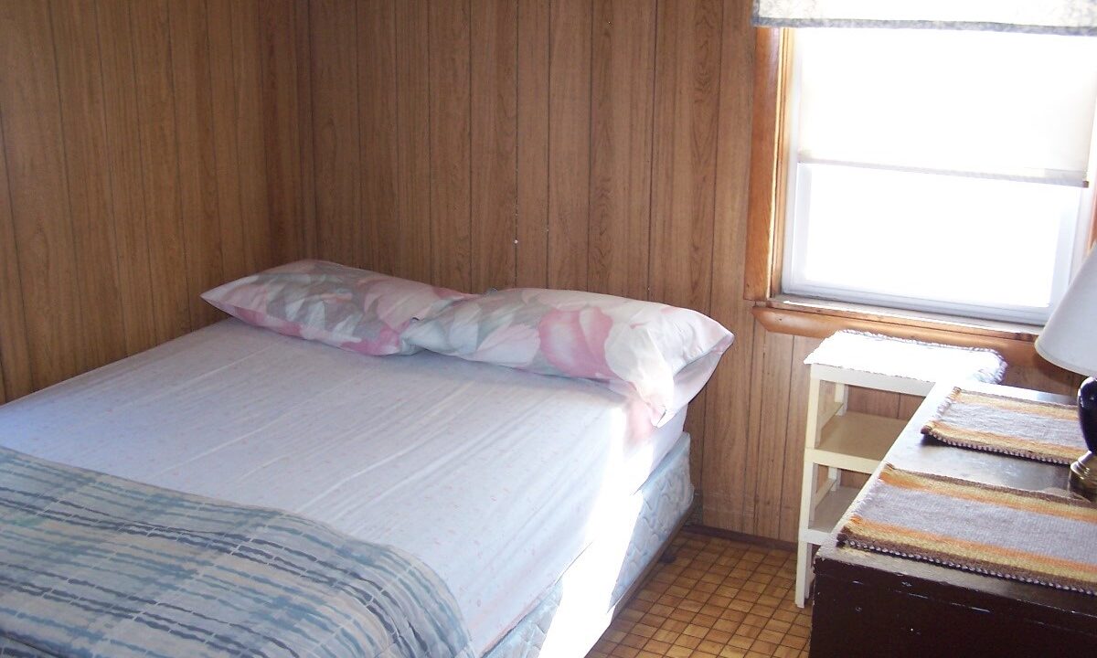 a small bed in a small room with a window.