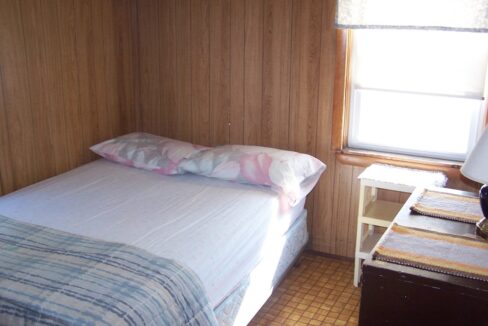 a small bed in a small room with a window.