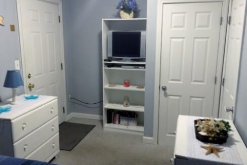 a bedroom with blue walls and white furniture.