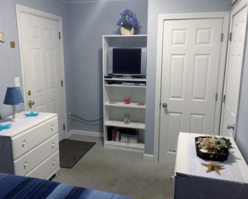 a bedroom with blue walls and white furniture.