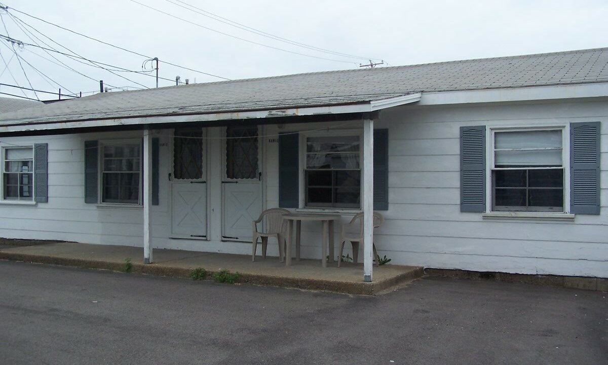 a white house with a table and chairs in front of it.