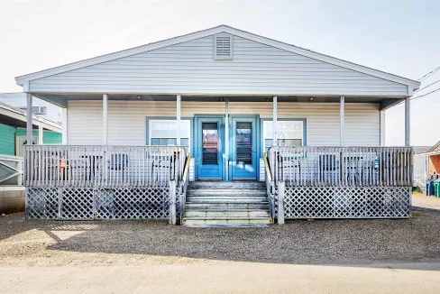 a small white house with a blue door.