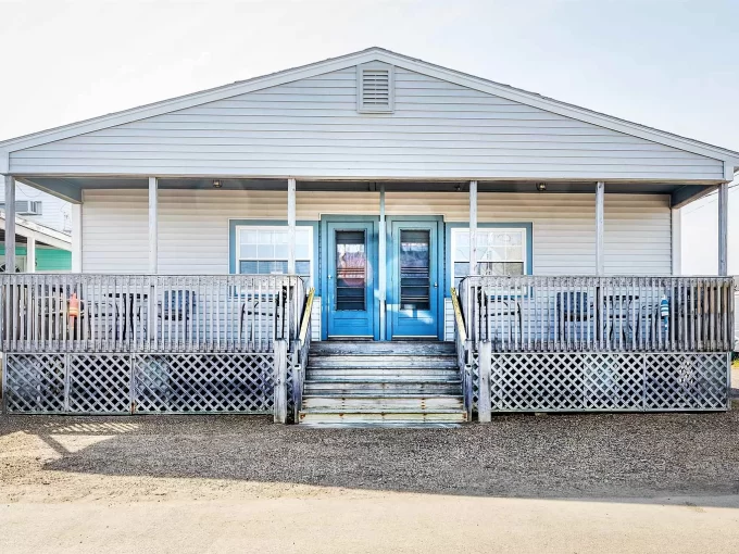 a small white house with a blue door.
