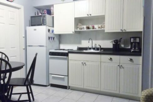 a kitchen with white cabinets and a black table.