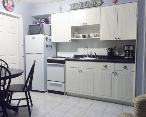 a kitchen with white cabinets and a black table.
