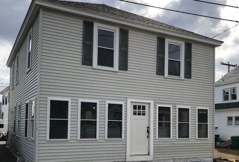 a two story house with a white door and windows.