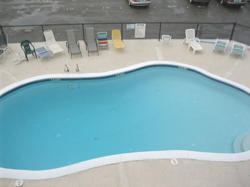 an empty swimming pool with chairs around it.