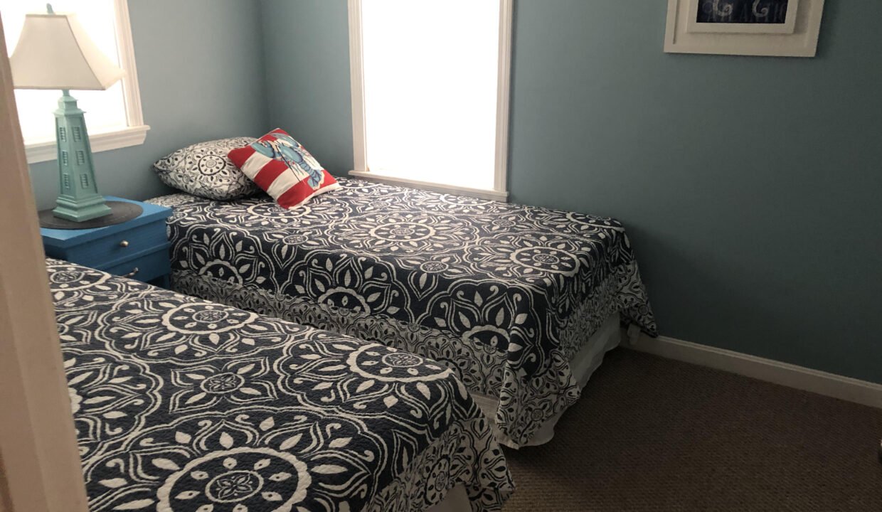 two twin beds in a bedroom with blue walls.