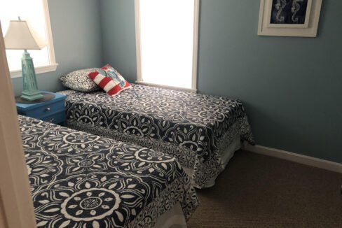 two twin beds in a bedroom with blue walls.