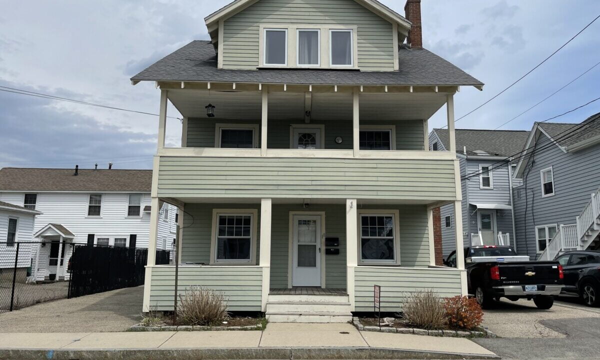 a two story house with a truck parked in front of it.