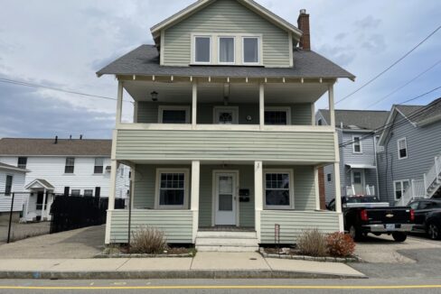 a two story house with a truck parked in front of it.