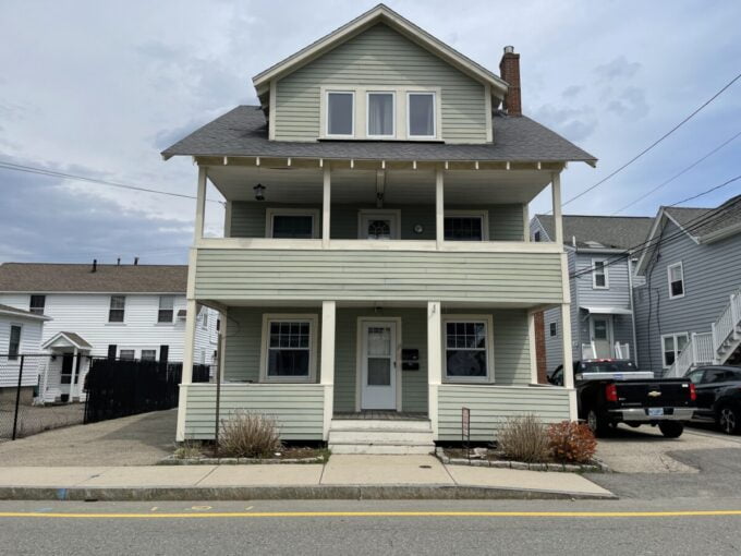 a two story house with a truck parked in front of it.