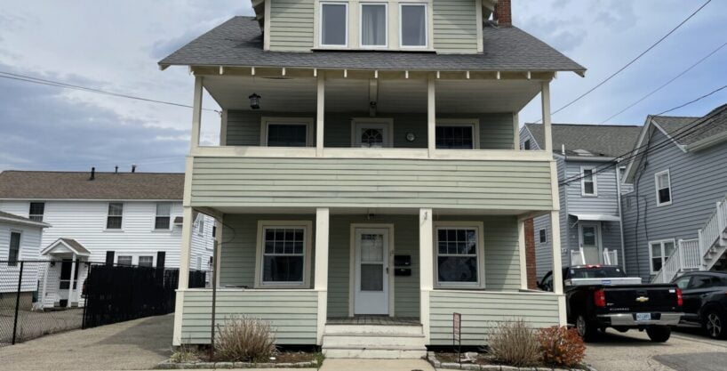 a two story house with a truck parked in front of it.