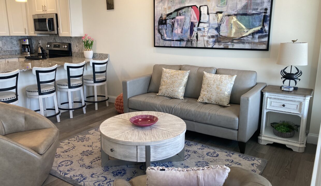 a living room filled with furniture and a painting on the wall.