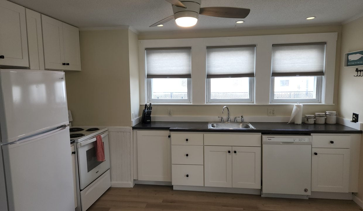 a kitchen with white cabinets and white appliances.