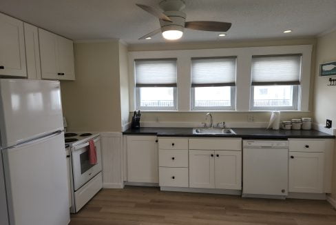 a kitchen with white cabinets and white appliances.