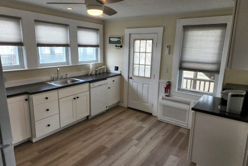 a kitchen with white cabinets and black counter tops.