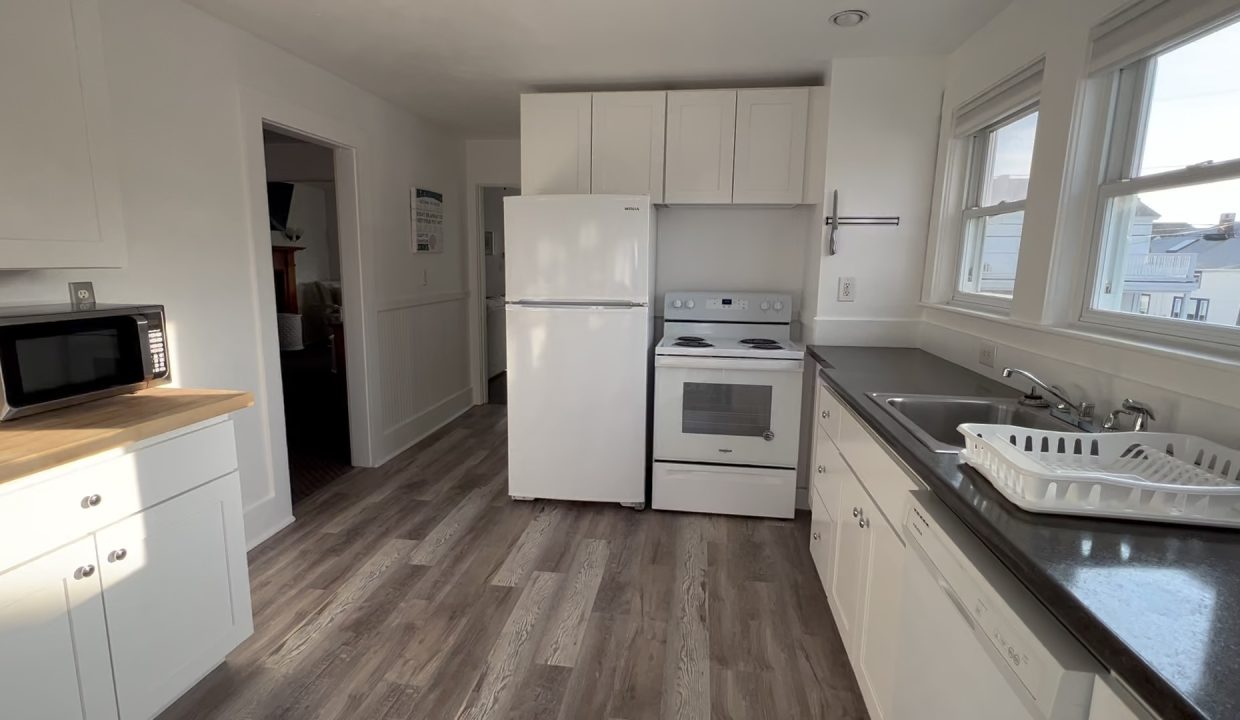 a kitchen with a sink, stove and microwave.